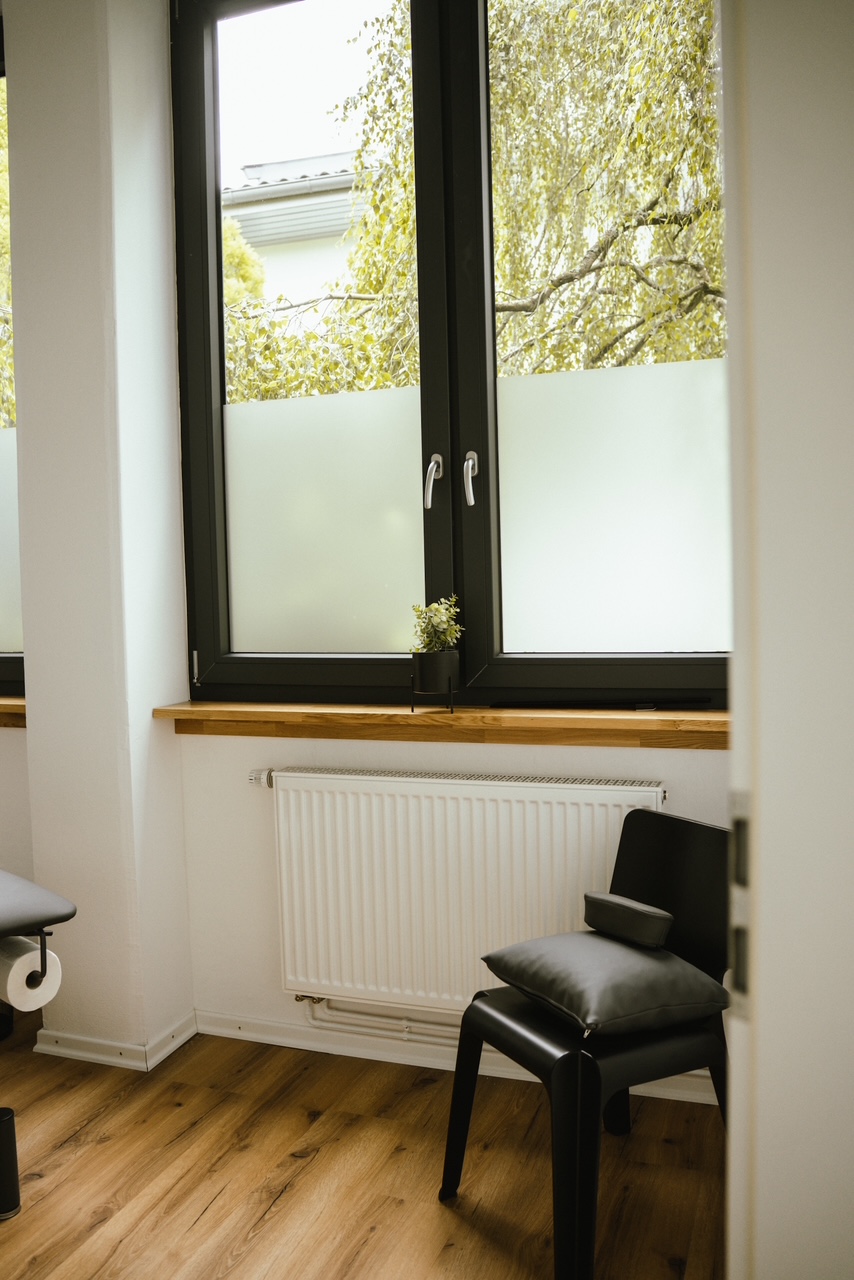 Heller Behandlungsraum im PhysioLab mit großem Fenster