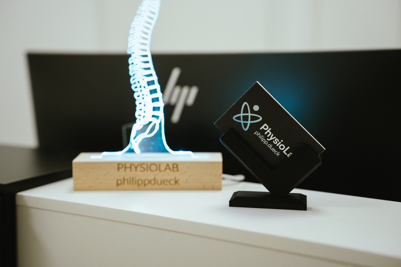 Nahaufnahme der PhysioLab-Visitenkarten und der Wirbelsäulenleuchte